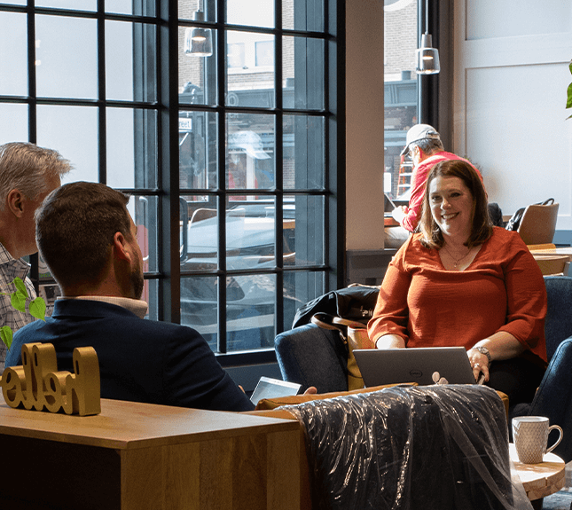 two men and a woman sitting in lobby