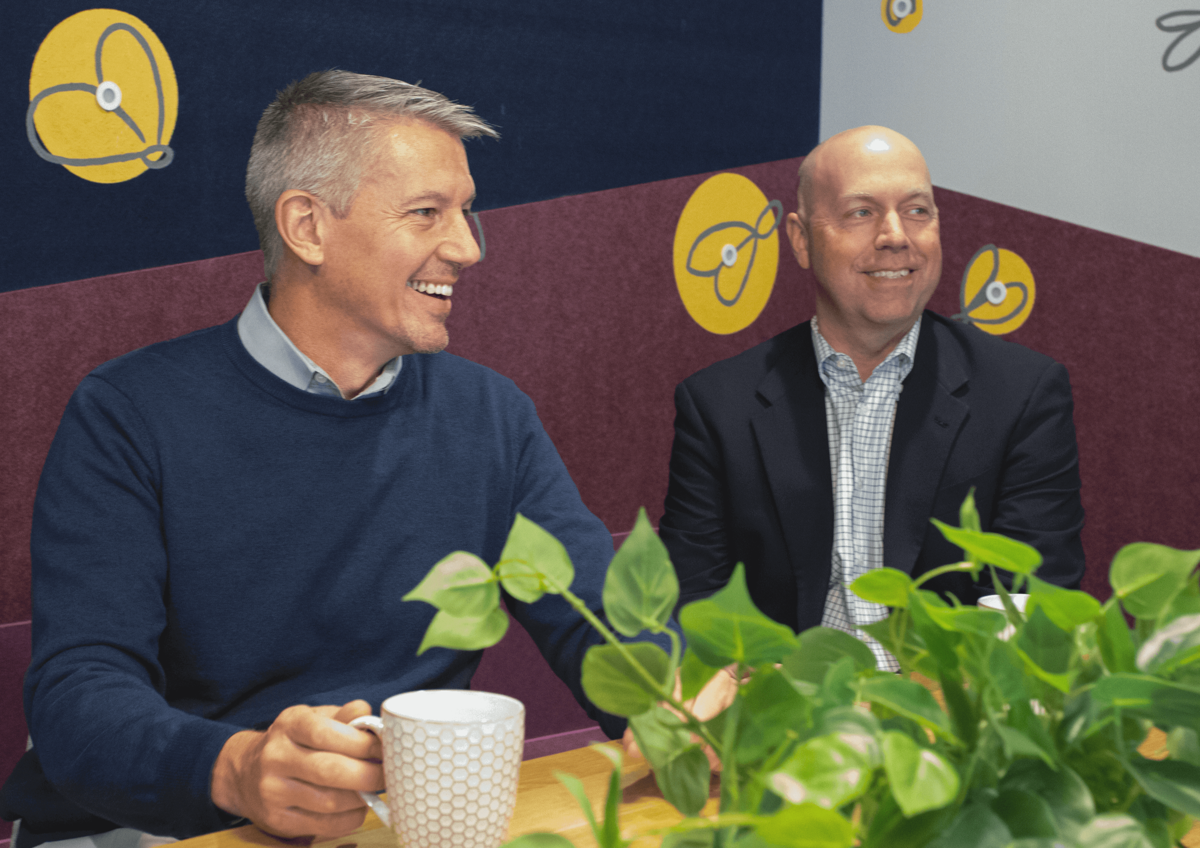 Walt Eckert and John Copeland smiling while at a conference table